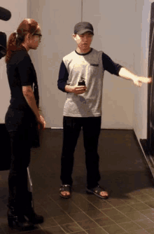 a man and a woman are standing next to each other on a tiled floor in a room .