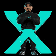 a man standing in front of a large x with his arms crossed