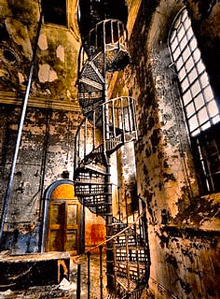 a spiral staircase in an abandoned building with a lot of windows