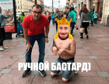 a man in a red shirt stands next to a shirtless man with a crown on his head with russian writing on the ground