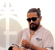 a man with a beard is wearing sunglasses and a bracelet