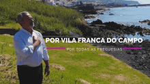 a man stands in front of a body of water with the words por vila franca do campo written above him