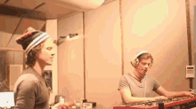 a man wearing headphones is playing a keyboard in a room