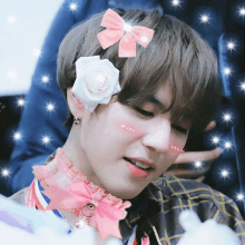 a boy with a flower in his hair has a pink bow on his head