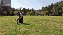 a woman playing with a dog in a grassy field with a screen behind her that says ' like coming party girl '