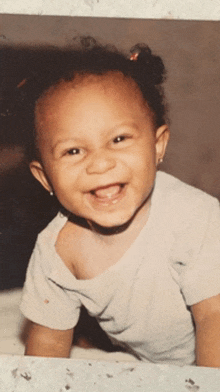 a little girl with pigtails is smiling for the camera