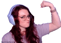 a woman wearing headphones and glasses flexes her biceps