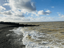 a large body of water with a blue sky and clouds in the background