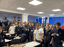 a group of young people are posing for a picture in a room with a robot on the wall behind them that says ctrl