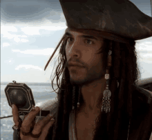 a man in a pirate costume holds a compass in his hand