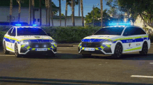 a couple of police cars are parked next to each other on the street .