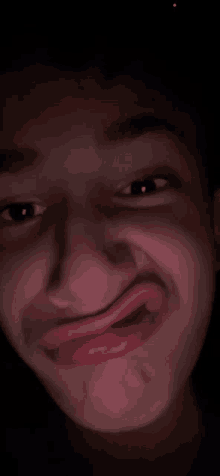 a close up of a person making a funny face in the dark