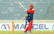 a cricket player is swinging a bat in front of an ad for marcel