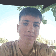 a young man is taking a selfie with a tree in the background