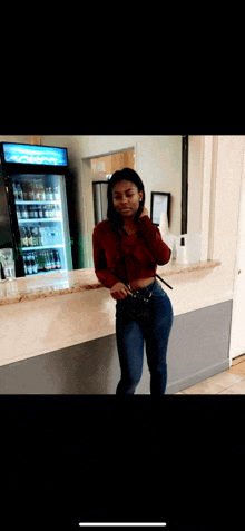 a woman is standing in front of a counter with a cooler that says ' coca cola ' on it