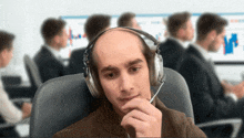 a bald man wearing headphones with a microphone on his head