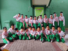 a group of children posing for a picture in front of a sign that says " jaya putri "