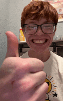 a man wearing glasses is smiling and giving a thumbs up sign