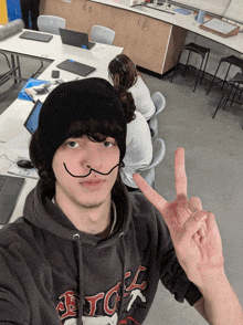 a young man wearing a black beanie and a hoodie that says tc on it