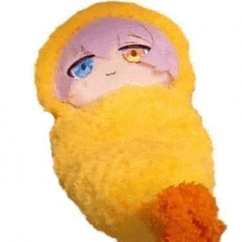 a stuffed animal wrapped in a yellow blanket with a blue eye and purple hair .