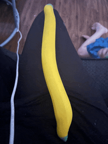 a person laying on a couch with a yellow banana on their lap