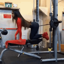 a woman is doing exercises on a bench in a gym with a sign on the wall that says " exit "