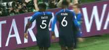 a soccer player with the number 6 on his back stands next to another player