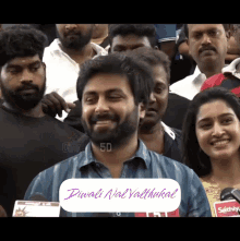 a man with a beard is smiling in front of a crowd with the words diwali nal valthukkal written on the bottom