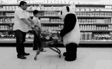 a panda bear is pushing a shopping cart in a supermarket while a man and a child look on .