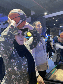 a woman holds a basketball above her head in front of a sign that says starbucks