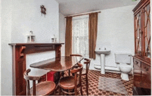 a dining room with a table and chairs a sink and a toilet