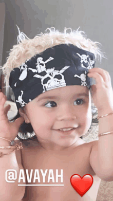 a baby wearing a bandana with skulls and crossbones and the name avayah