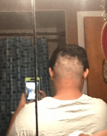 a man is taking a picture of his head in a mirror