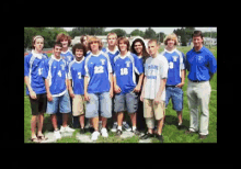 a group of young men are posing for a picture with one wearing a shirt that says t on it