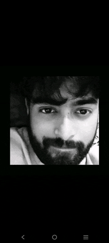 a black and white photo of a man with a beard and a white shirt .