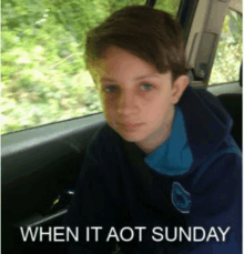 a young boy is sitting in the back seat of a car with a caption that says when it aot sunday .