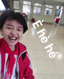 a young boy in a red and white uniform is smiling in a hallway with the words " eone ne " written on the floor