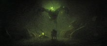 a man sitting in a chair in front of a monster in a dark room