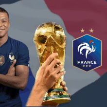 a soccer player holds a trophy in front of a france logo