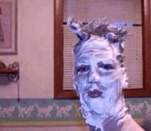 a man 's face is covered in shaving cream and foam .