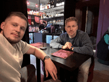 two men sit at a table with a menu on it that says ' steak lovers ' on it