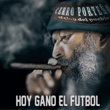 a man with a beard is smoking a cigar with the words hoy gano el futbol below him