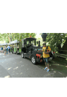 a man in a yellow shirt stands in front of a train with a license plate that says gk - cb - 354