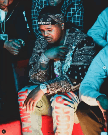 a man wearing a bandana with the word shock on it sits in a crowd