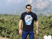 a man wearing sunglasses and a black shirt with a picture of a woman on it