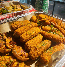 a tray of fried food including shrimp and cheese sticks with a christmas tree in the background