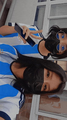 two girls wearing face masks and sunglasses pose for a photo