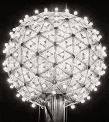 it is a black and white photo of a ball made of lights .