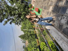 a person standing on a railing with trees in the background and a sign that says ' a ' on it