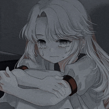 a sad anime girl is crying with tears running down her face while sitting down .